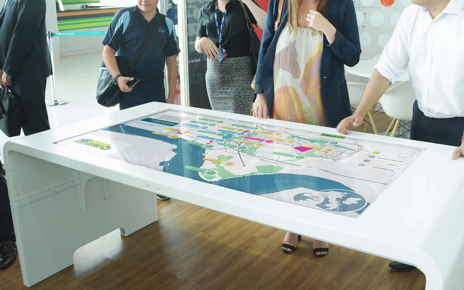 group of people interacting with Ebbsfleet touchscreen display on white table in office