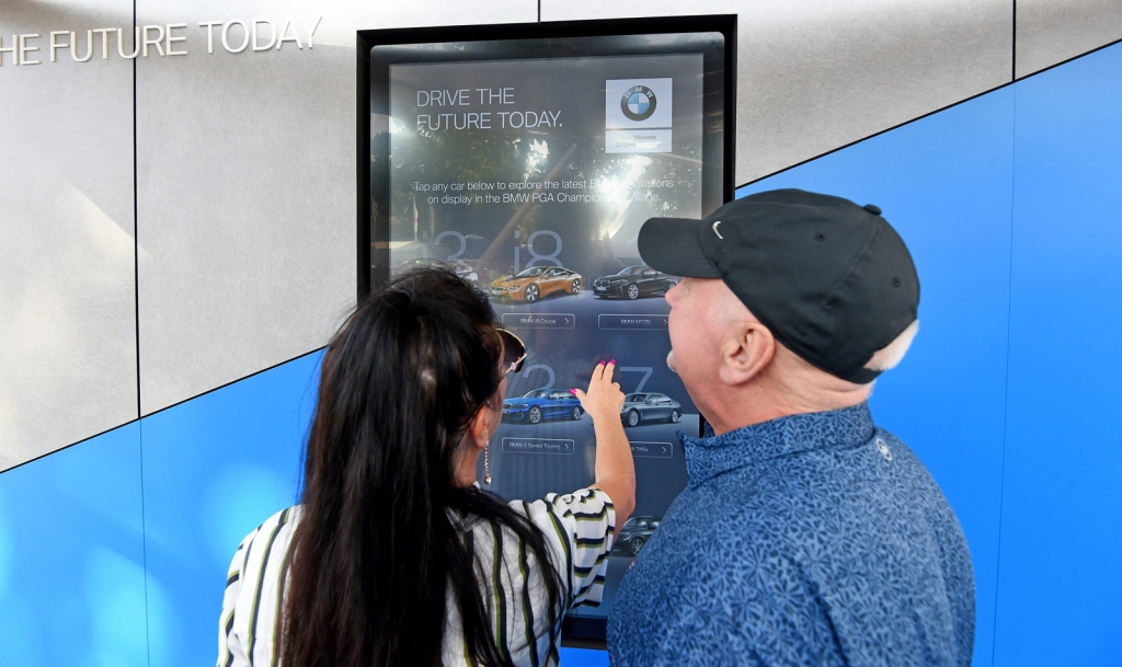 Two visitors using an interactive Touchscreen experience developed for BMW   