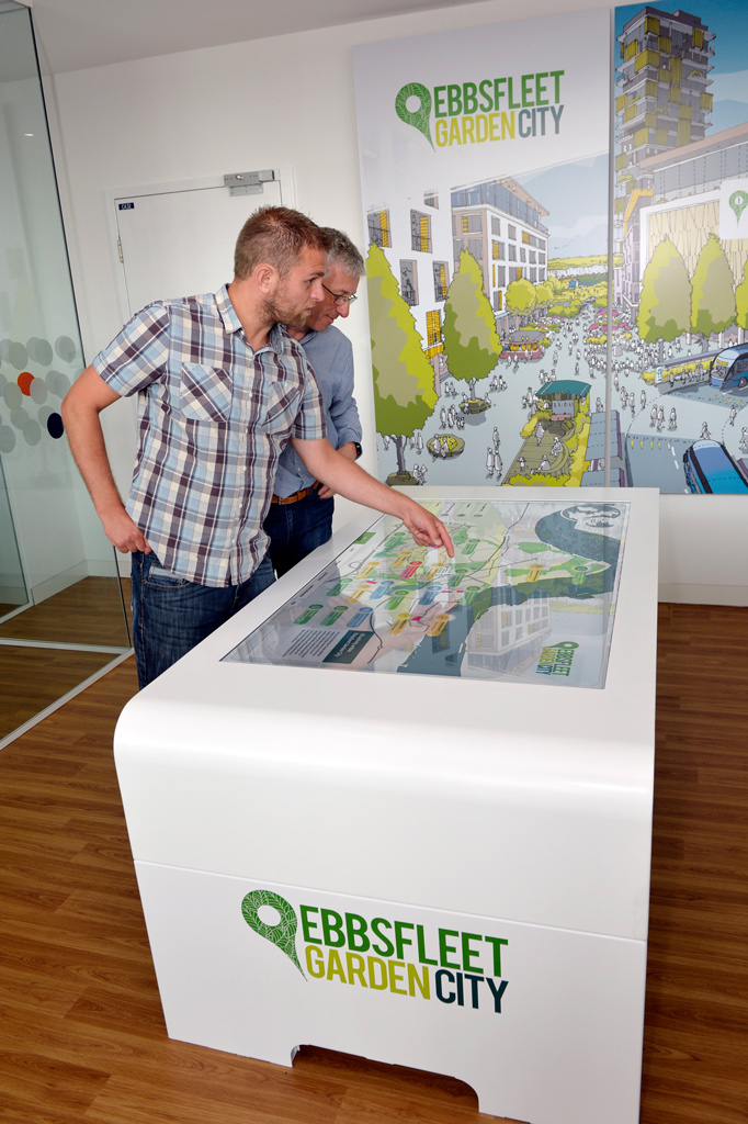 two men interacting with Ebbsfleet Garden City touchscreen presentation interactive map on large white monitor